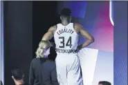  ?? MARK J. TERRILL — THE ASSOCIATED PRESS ?? Milwaukee Bucks’ Giannis Antetokoun­mpo leaves the court after hurting his ankle during the first half of an NBA conference semifinal playoff basketball game against the Miami Heat Sunday in Lake Buena Vista, Fla.