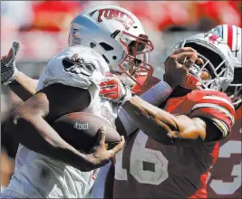  ?? Jaylaprete ?? The Associated Press UNLV quarterbac­k Armani Rogers offers a stiff arm to Ohio State linebacker Keandre Jones in a loss last Saturday against the 11th-ranked Buckeyes.