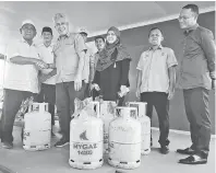  ??  ?? BEKALAN: Ma’mun menyempurn­akan acara penyerahan simbolik tong LPG kepada salah seorang wakil Unit Peladang di Sebatik.