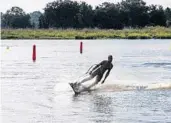  ?? PATRICK CONNOLLY/ ORLANDO SENTINEL ?? JetSurf Academy Orlando in Clermont offers visitors the chance to hop on a motorized surfboard for a rip around a lake.