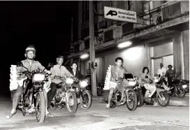  ??  ?? Below: Messenger boys get ready to deliver the Bangkok Post to subscriber­s’ homes.