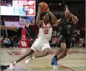  ?? KEVIN M. COX — THE ASSOCIATED PRESS ?? Houston guard Tramon Mark (12) drives around Memphis guard Elijah McCadden (0) during the second half on Sunday in Houston. Mark and the Cougars returned to No. 1 in the AP men's college basketball poll on Monday.