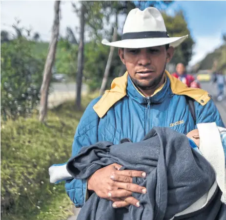  ??  ?? Migrantes venezolano­s, ayer, en su caminata por una ruta colombiana, con destino a Perú