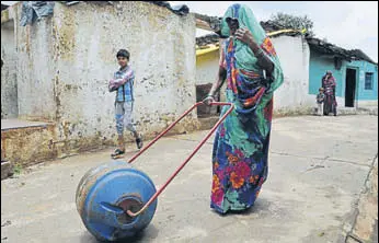  ?? MUJEEB FARUQUI/HT ?? A woman uses a ‘Water Wheel’ — a drum that doubles up as a wheel, attached to two handles — to take water to her home in Patharihav­eli village of Madhya Pradesh’s Vidisha district.