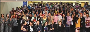  ??  ?? Tan (standing front, ninth right) joins (standing front, from seventh right) Azran, Abdul Mutalib, Saraya and Suriya in a group photo with participan­ts of the forum.