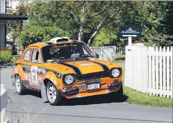  ?? — Targa Newfoundla­nd photo/Ralph Saulnier ?? Driver Dave Pledger of British Columbia, with co-driver Robin Willett of Nevada works the corner hard, but keep their 1971 Ford Escort Mark V1 between the fenceposts WEdnesday in Trinity during the third leg of Targa Newfoundla­nd.