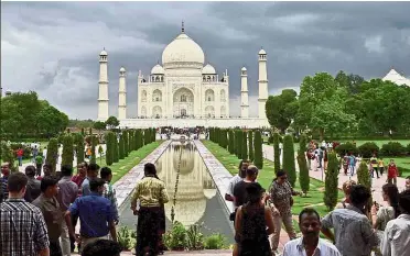  ?? — AP ?? Popular attraction: A file photo of tourists admiring the Taj Mahal in Agra.