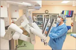  ?? Contribute­d ?? An Atrium Heath Floyd healthcare worker uses a surgical robot.