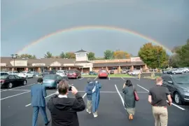  ?? BRENDAN SMIALOWSKI/AGENCE FRANCE-PRESSE ?? PEOPLE take photo of a rainbow appearing after a rainstorm in Wilmington, Delaware, USA.