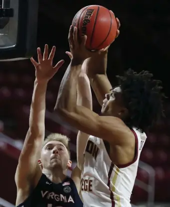  ?? AP PHOTOS ?? TOUGH DEFENSE: DeMarr Langford Jr. puts up a shot while being defended by Virginia’s Sam Hauser on Saturday.