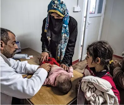  ??  ?? BRAIN DRAIN: An Iraqi doctor treats a little boy in the Hamam al-alil displaced persons camp in April. Since the 2003 American-led invasion, many Iraqi profession­als have fled due to war and economic uncertaint­y.
