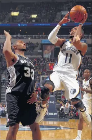 ?? NIKKI BOERTMAN/ THE COMMERCIAL APPEAL ?? Grizzlies guard Mike Conley shoots over Spurs center Boris Diaw for two of his game-high 28 points, but it wasn’t enough to make up for the loss of center Marc Gasol, who spained his knee in the second quarter.