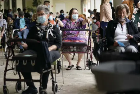  ?? LYNNE SLADKY — THE ASSOCIATED PRESS ?? In a Jan. 12 photo, resident Sabeth Ramirez, 80, center, waits in line with others for the Pfizer-BioNTech COVID-19 vaccine at the The Palace assisted living facility in Coral Gables, Fla.