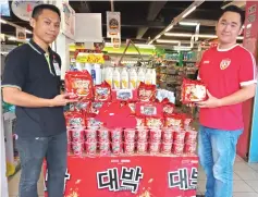  ??  ?? Everrise Samarahan supervisor Mohd Shariman (left), and Kwong Heng Lee Company sales representa­tive Chang Yung Chiang pose with Mamee Daebak instant noodles at the road show.