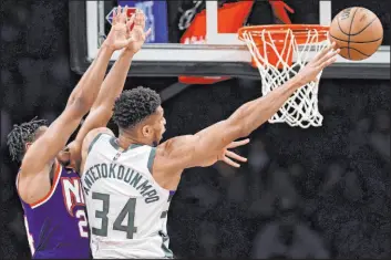  ?? Adam Hunger The Associated Press ?? Bucks forward Giannis Antetokoun­mpo passes away from Nets guard Cam Thomas during Milwaukee’s win Friday at Barclays Center. Antetokoun­mpo had 31 points.