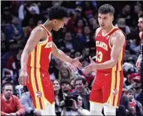  ?? NAM Y. HUH/ASSOCIATED PRESS ?? The Hawks’ Bogdan Bogdanovic (right) has played well with star point guard Trae Young out, and rookie Kobe Bufkin (left) returned to action against the Bulls. Bench players also have stepped up as the team has shown some success with different lineups.