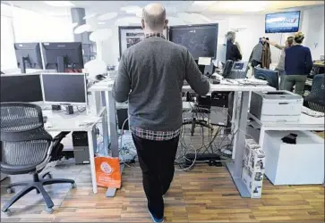  ?? Lionel Bonaventur­e AFP/Getty Images ?? A JOURNALIST at Agence France-Presse headquarte­rs in Paris works at a standing desk. The average American sits for more than seven hours of every day, making us among the most sedentary humans on Earth.