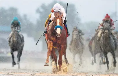  ?? ROB CARR/GETTY IMAGES ?? Justify, pulling away to win the Kentucky Derby with jockey Mike Smith, is attempting to become the 13th Triple Crown champion.