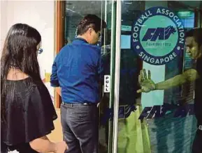  ?? AFP PIC ?? Investigat­ors entering the Football Associatio­n of Singapore office during a raid on Thursday.