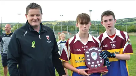  ?? Photo by Michelle Cooper Galvin ?? Christy O’Leary, East Kerry Board presenting Trevor O’Sullivan and Redmnond O’Connor, Joint captains Cordal Scartaglen who defeated Listry Keel in the East Region Coiste nÓg U14 division 4 final in Cordal on Monday