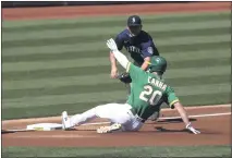  ?? JED JACOBSOHN — THE ASSOCIATED PRESS ?? The A’s Mark Canha slides safely into third as the Mariners’ Kyle Seager applies the tag during the first inning of their first game of a doublehead­er in Oakland on Saturday.