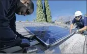  ?? Irfan Khan Los Angeles Times ?? WORKERS install a solar panel in Van Nuys. The U.S. plans to impose tariffs on imported panels.