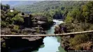  ??  ?? Die steilen Schluchten und Hänge Südalbanie­ns: Touristen auf der Hängebrück­e über den oberen Teil der Vjosa