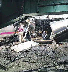  ?? WILLIAM SUN VIA AP ?? People examine the wreckage of a New Jersey Transit commuter train that crashed into the train station during the morning rush hour in Hoboken, N.J. The crash killed one person and injured dozens.