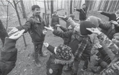  ?? BERNARD WEIL PHOTOS/TORONTO STAR ?? Children from Thornwood Public School and their parents watch as field centre co-ordinator Rob Ridley lures chickadees with a handful of seeds.