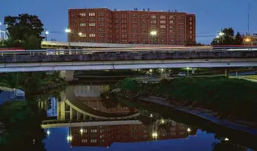  ?? Mark Mulligan / Staff photograph­er ?? Vehicles cross Buffalo Bayou west of the Harris County Jail in downtown Houston. Harris County is looking to switch to using renewable energy to power its buildings, something the city is already doing.