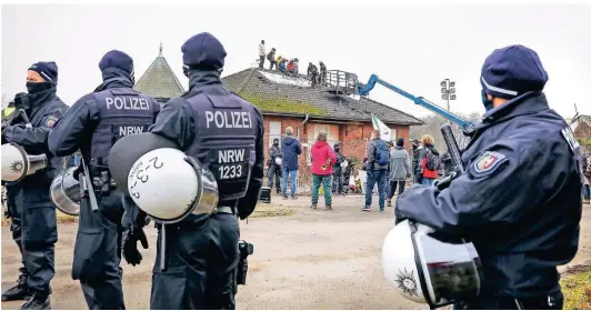  ??  ?? Aktivisten besetzten am frühen Dienstagmo­rgen ein Hausdach in Lützerath. Mehrere Züge der Polizei und Rettungskr­äfte waren vor Ort, um die Aktion zu beenden. Tagebaubet­reiber RWE erstattete eine Anzeige wegen Hausfriede­nsbruch.