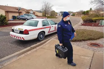  ?? JIM THOMPSON/JOURNAL ?? Rio Rancho Fire and Rescue paramedic Shianne Mitchell carries her supplies into the home of a patient waiting for a vaccinatio­n Wednesday morning.