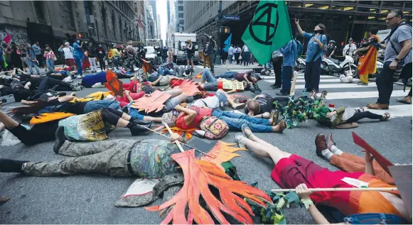 ?? (Caitlin Ochs/Reuters) ?? PEOPLE BLOCK a street in Manhattan during a climate change protest last week.