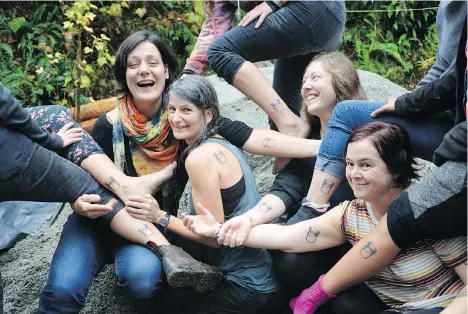  ??  ?? The Mudgirls sport simple bucket tattoos that they say exemplify their purpose: “It’s our favourite tool. An empty bucket. It’s full of potential.”