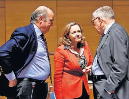  ?? / J. W. (EFE) ?? Desde la izquierda, el vicepresid­ente del BCE, Luis de Guindos, la ministra de Economía en funciones, Nadia Calviño, y el director del mecanismo europeo de estabilida­d, Klaus Regling, el viernes en Luxemburgo.