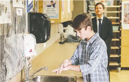  ?? GOVERNMENT OF B.C. ?? Minister of Education Rob Fleming watches a student at Monterrey Middle School in Victoria use a new handwashin­g station back in June. With classes to resume in two weeks, teachers are pressing the province to do more to prevent the spread of COVID-19 among students.