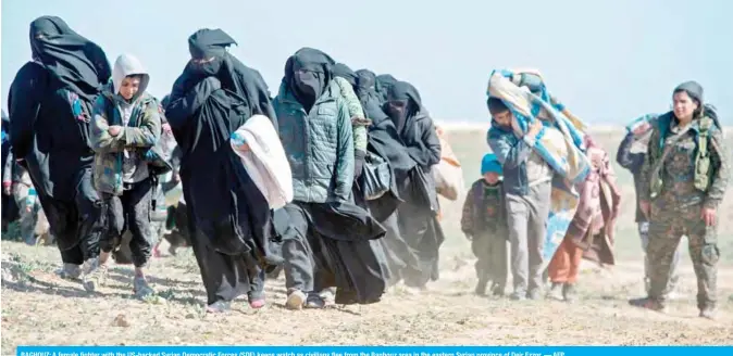  ??  ?? BAGHOUZ: A female fighter with the US-backed Syrian Democratic Forces (SDF) keeps watch as civilians flee from the Baghouz area in the eastern Syrian province of Deir Ezzor. — AFP