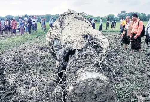  ?? EPA ?? Local residents look at the wreckage of a Myanmar air force F-7 fighter jet after it crashed near Saklu City, Minbu Township, Magway Division, Myanmar.