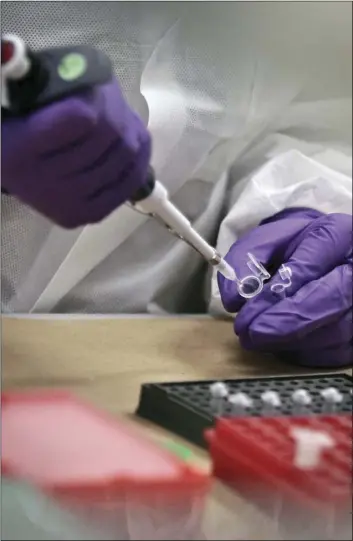  ??  ?? In this April 15, 2014, file photo, a criminalis­t trainee prepares sample bone fragments for DNA testing at the training lab in the Office of Chief Medical Examiner in New York. A technique for analyzing DNA evidence developed by the laboratory has...