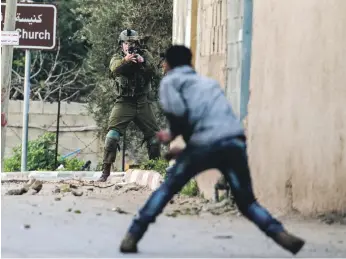  ?? AFP ?? A Palestinia­n protester confronts an Israeli soldier during an army search operation in the occupied West Bank village of Burqa, about 18 kilometres north-west of Nablus