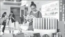  ?? SU YANG / FOR CHINA DAILY ?? A visitor reads a book at the expo held in Jiangsu.