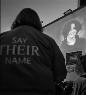  ?? NATE BILLINGS / THE OKLAHOMAN VIA AP ?? A photograph of Nex Benedict, a nonbinary teenager who died a day after a fight in a high school bathroom, is projected during a candleligh­t service Feb. 24 at Point A Gallery in Oklahoma City.