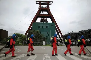  ??  ?? Einzelkämp­fer gibt es nicht bei der Grubenwehr: Auf dem Weg zum Training in der ehemaligen Zeche Pluto in Herne