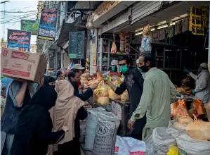  ?? AP ?? BACK TO BUSINESS: People buy grocery at a market in Rawalpindi on Thursday after the government announced some relaxation­s in the lockdown restrictio­ns. —