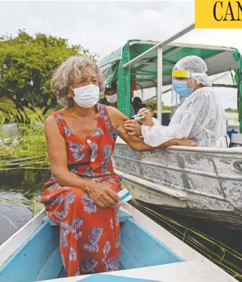  ?? MICHAEL DANTAS / AFP VIA GETTY IMAGES ?? Olga D'arc Pimentel, 72, is vaccinated by a health worker with a dose of Astrazenec­a's COVID-19 vaccine near Manaus, Brazil, on Tuesday. The rate of vaccinatio­n in the developing world is badly lagging that in richer countries.