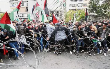  ?? — AP ?? Getting rowdy: Protesters trying to remove barbed wires that block a road leading to the US Embassy during a demonstrat­ion in Aukar, east Beirut, Lebanon.