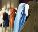  ??  ?? Ein iranischer Tschador (rechts) und eine Burka neben anderen weiblichen Kopfbedeck­ungen. Foto: Christophe Gateau