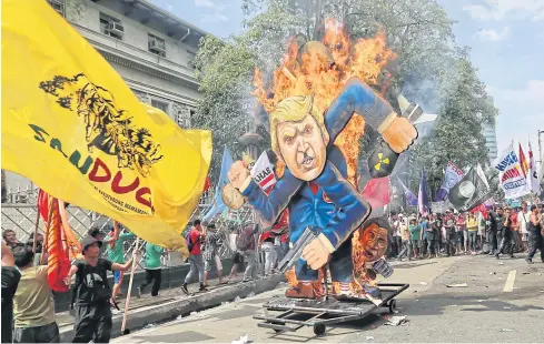  ?? EPA-EFE ?? Philippine activists burn an effigy of US President Donald Trump during a rally outside the Asean summit in Manila yesterday.