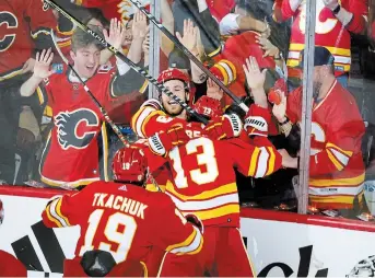  ?? JEFF MCINTOSH THE CANADIAN PRESS ?? Flames forward Johnny Gaudreau (13) celebrates his goal with teammates during overtime against the Dallas Stars in Calgary late Sunday night. Calgary won the game 3-2, and next up is an old Alberta rival, the Edmonton Oilers.