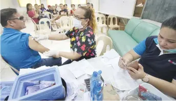  ?? JOY TORREJOS ?? A nurse administer­s anti-rabies vaccine to Casuntinga­n Captain Oscar Del Castillo of Mandaue City as other victims of the dog attack last Saturday look on.